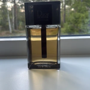 Dior Homme Intense Eau de Parfum 150ml - Dior Homme Intense Eau de Parfum i en stilren, rektangulär glasflaska med svart lock och detaljer. Flaskan rymmer 150 ml och har en elegant, bärnstensfärgad vätska. Klassisk och lyxig doft för dig som gillar exklusiva parfymer. Paket medkommer samt köp bevis 