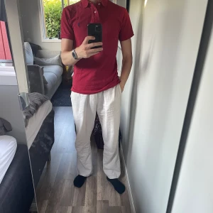 Ralph Lauren piké röd - Snygg röd pikétröja från Polo Ralph Lauren med klassisk krage och deras ikoniska broderade logga på bröstet. Perfekt för dig som gillar stilren och enkel design. Nypris runt 1500 kr. Liten vit fläck längst ner till höger (se på bilderna) men borde gå bort med starkare medel likt vanish. 