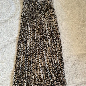 Leopardmönstrad långkjol  - Snygg  långkjol i leopardmönster. Kjolen har beige och svarta toner och ett elastiskt midjeband för skön passform så även om storlek är 34 så hade det också passat för 36! Eftersom den är väldigt stretchig som ni ser så är bandet kvar men inte prislappen, den har knappt används. Jag finns tillgänglig i Skövde, Borås & Värnamo❤️. 