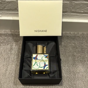 Nishane Tero Extrait de parfum  - Unik parfym från Nishane, Tero Extrait de Parfum. Flaskan är fyrkantig i glas med en färgglad etikett i blått, grönt, rött och guld. Locket är i metall med guldfinish och har en modern, stilren form. Kommer i elegant svart ask med vit lock. Inte andvänd eller så, 4000kr på nätet men här får du den för 3000kr