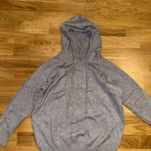 Grå merino ull hoodie - Säljer en bekväm grå merino ull hoodie i XS med justerbar dragsko i huvan. Perfekt för en avslappnad stil. Den har långa ärmar och en mjuk känsla. Helt ny, aldrig använd då den va för liten!