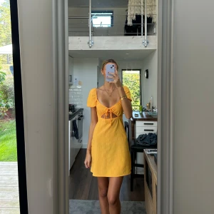 Gul kort klänning med puffärm och knyt H&M - Superfin gul kort klänning med puffärmar och snygg knytning framtill. Klänningen har en v-ringad urringning och en cut-out detalj under bysten. Materialet känns lätt och somrigt, perfekt för varma dagar. Söt och trendig modell som verkligen sticker ut!