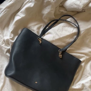 black school bag - a balck bag with golden details. it fits a laptop. good condition. the measurements are 43cm x 31cm