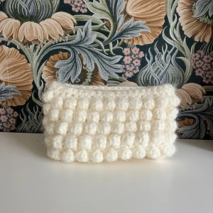 Virkad vit fluffig clutch/necessär - Virkad vit fluffig clutch/necessär som är perfekt nu till höstens alla tillfällen. Längd 23cm, höjd 12cm, djup 8 cm vilket gör att den är rymligare än vad man kan tro. Skriv gärna till mig om du har frågor eller ett prisförslag💕