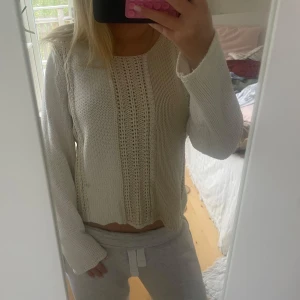 Vit stickad tröja från Wico - Säljer en vit stickad tröja från Wico med snygga virkade detaljer framtill. Tröjan har lång ärm, rund halsringning och en lite lösare passform. Perfekt att slänga på sig när det är kyligt ute. Superenkel att matcha med jeans eller kjol! har nån fläck nån stans men inte testat om det går bort i tvätten!