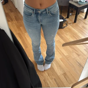 Ljusblå bootcut jeans - Säljer ett par ljusblå jeans med bootcut-modell och klassisk femficksdesign. Jeansen har normal passform och är tillverkade i mjukt denimtyg. Perfekta för dig som gillar en avslappnad men ändå snygg stil.