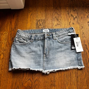 Blå jeanskjol från Weekday - Jeans kjol från Weekday storlek 40. Känns som den är lite mindre i storleken dock, oanvänd och prislapp kvar. 