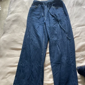 Mörkblå wide jeansbyxor med snörning och en matchande topp - Mörkblått set med jeansbyxor och topp från SHEIN med bred passform och elastisk midja med snörning. Byxorna har klassiska fickor fram och raka ben med en croppad top till!💙🩵💙🩵