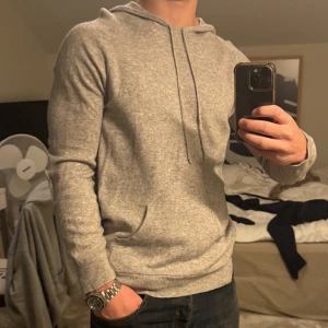 DAVIDA Hooodie - Säljer en ljusgrå, 100% kashmir-hoodie från Davida. Sparsamt använd, men har sytt på lappar på armbågarna hos en skräddare då de såg lite slitna ut. Perfekt nu till hösten o vintern då den är varm och väldigt skön. 