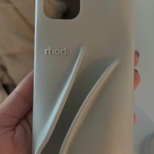 Rhode mobilskal  - Ett as snyggt Rohde mobilskal i den gråa klassiska färgen. Helt nytt men kan ej använda då jag har en ny telefon nu, passar 12,13,14. 