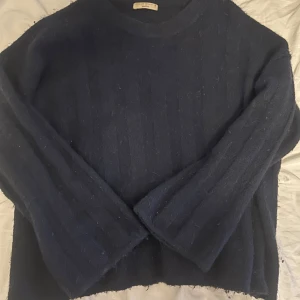 Marinblå stickad tröja från gina tricot - Säljer en mysig marinblå stickad tröja från gina tricot med diskret randigt mönster. Tröjan har lång ärm och en klassisk rund halsringning. Perfekt till hösten. Den är lite ”oversize” och passar jätte bra till allt. Tröjan går inte längre att köpa i butik.