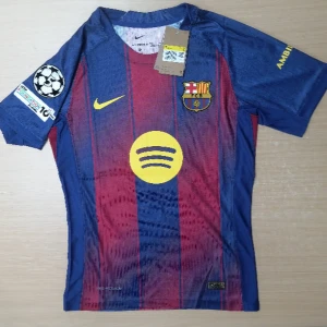 FC Barcelona Lamine Yamal #10 Nike tröja - Snygg FC Barcelona matchtröja med Lamine Yamal och nummer 10 på ryggen. Tröjan har klassiska blå och vinröda ränder, gula detaljer och klubbmärke på bröstet. Tillverkad i lätt polyester med korta ärmar och Champions League-märke på axeln. Perfekt för dig som älskar Barca!