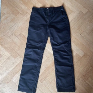 Svarta chinos från Vans, storlek 29 - Köparen står för frakten. Säljer ett par svarta Vans Authentic Chino i klassisk rak modell. Förutom att dom är lite skrynkliga är det inget fel på dom. Snygg röd detaljsöm på insidan av linningen. 