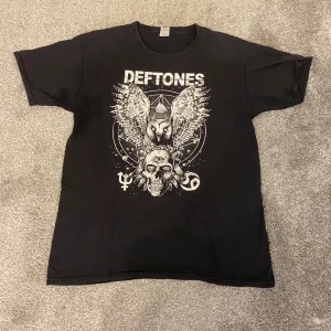 Deftones t-shirt - T-shirt med stort vitt Deftones-tryck framtill. Perfekt för dig som gillar bandmerch och coola grafiska prints.