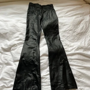 Svarta bootcut byxor i skinnimitation Zara - Snygga svarta bootcut byxor från Zara i skinnimitstation, säljer pga att jag har ett par exakt likadana❤️har sprättat ut dom längst ner 