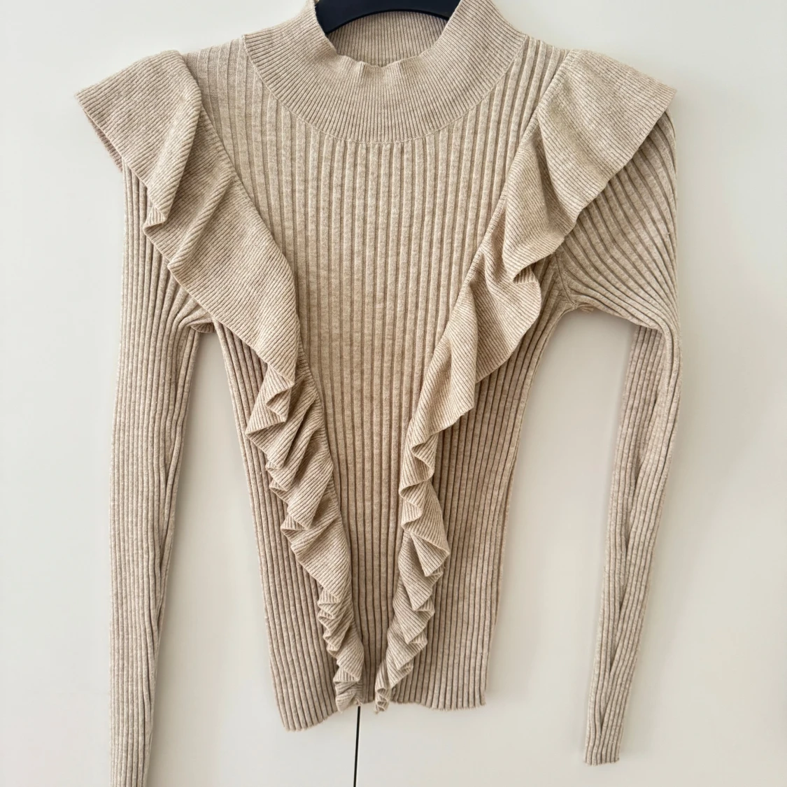 Beige ribbad stickad tröja med volang