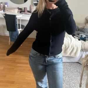 Svart kofta med knappar - En klassisk svart kofta med rund hals och knäppning framtill. Långärmad och i mjukt, tunt material som passar perfekt till jeans eller över en topp. Enkel och stilren design som funkar till många olika outfits!! 😍 Använd 1 gång 