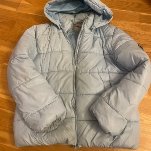 Ljusblå pufferjacka från Only - Säljer en ljusblå pufferjacka från Only med huva och dragkedja. perfekt för kalla dagar. Enkel och stilren design som passar till det mesta.