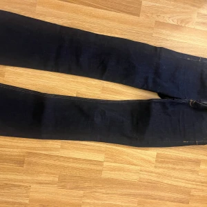 Mörkblå jeans från Zara - Snygga mörkblå jeans från Zara med klassisk femficksdesign och kontrastsömmar. Jeansen har en rak passform och är tillverkade i ett mjukt bomullsmaterial med lite stretch för extra komfort. Perfekta till sneakers eller boots.