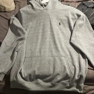 Grå hoodie från Polo Ralph Lauren - Snygg grå hoodie från Polo Ralph Lauren med klassisk broderad logga på bröstet.  Skickas snabbt och priset är prutbart vid snabb affär 