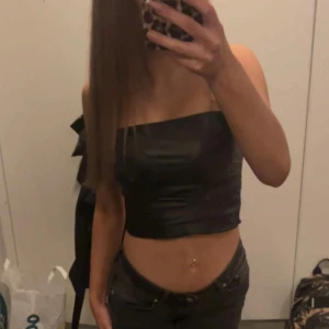 Skinn topp - Snygg svart bandeau tubtopp i glansigt satinmaterial. Skinn topp använd få tan gånger i strl xs❤️❤️❤️från shein 