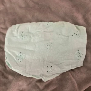 Ljusgrön topp från Bershka XS - Supersöt ljusgrön topp från  Bershka. Kjolen har broderade blommönster med små hål som ger en luftig och somrig känsla. Perfekt för dig som gillar en enkel men ändå söt stil.