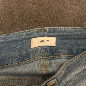 Ljusblå bootcut jeans från Nelly - Säljer de populära jeansen ifrån Nelly med bootcut-modell och slitna hål över knäna. Använder de inte längre pågrund av att de blivit för korta💕