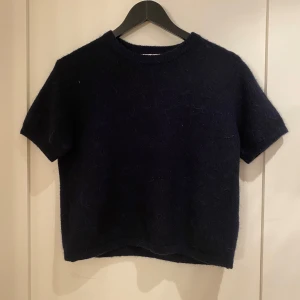 Mörkblå stickad tröja Gina Tricot - Mysig mörkblå stickad tröja från Gina Tricot med korta ärmar och rund halsringning.  Råka köpa för liten storlek och har aldrig använt den.💕