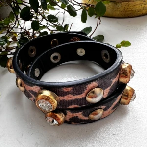 Leopardmönstrat armband med nitar och stenar - Coolt armband med leopardmönster i svart och beige, dekorerat med stora guldfärgade nitar och glittrande stenar Snygga detaljer och unik look som sticker ut. #armbnad 