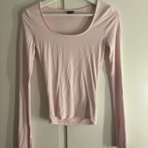 Ljusrosa långärmad topp Gina Tricot - Säljer en ljusrosa långärmad topp från Gina Tricot i storlek XS. Toppen har en rundad, djup urringning och är tillverkad i mjuk bomullsmix. Enkel och stilren design som är lätt att matcha med olika outfits.