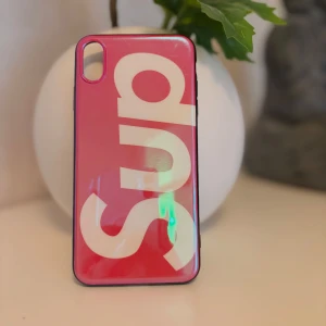 iPhone XR - Snygg iPhone XR med röd Supreme-inspirerad skal. Skalet har några mindre repor men mobilen ser ut att vara i gott skick. Perfekt för dig som vill ha en trendig och pålitlig smartphone med stor skärm och bra kamera.