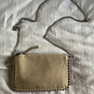 Väska - Super snygg väska med tre olika fack och mitten går att stänga. Kedjan är avtagbar så man kan ha den som handväska. Säljer även den svarta