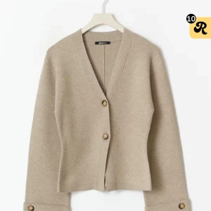 Beige kofta från Gina Tricot - Stilren beige kofta från Gina Tricot med v-ringning och två snygga knappar framtill. Koftan har långa ärmar med dekorativa knappar vid ärmsluten. Passar mig bra som vanligtvis har M. Använd två gånger nypris 459kr🫶🏼🫶🏼