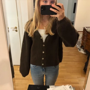 Mörkbrun kofta från Gina Tricot - Supermysig mörkbrun kofta från Gina Tricot med v-ringning. Använd en gång. 