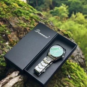 Grön klocka med metallarmband - Snygg klocka med grön urtavla och randigt mönster. Klockan har ett robust armband i silverfärgat rostfritt stål och tydliga markeringar på urtavlan. Quartz-urverk och datumvisning. Perfekt för dig som gillar stilrena accessoarer med lite edge. Kan justera storleken för extra pris.