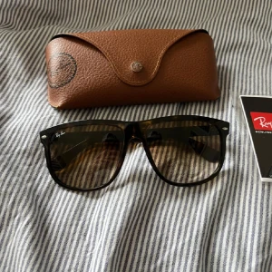 Ray-Ban boyfriends - Snygga Ray-Ban boyfriends solglasögon med brunmelerad båge och mörka tonade glas. Klassisk fyrkantig form och diskret Ray-Ban-logga på linsen. Kommer med original brunt fodral. Perfekt accessoar för soliga dagar.