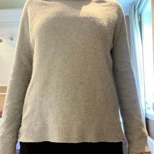 Turkos/grön  stickad tröja med rund hals - Enkel och stilren turkos/grön  stickad tröja med rund hals och långa ärmar. Tröjan har ribbade muddar vid ärmslut och nederkant, perfekt för lager-på-lager under kyliga dagar. Passformen är normal och materialet känns mjukt och skönt mot huden. Lite nopprig.