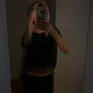 Svart transparent croppad blus - Säljer en svart, croppad blus med transparenta, korta ärmar och lätt genomskinligt material. Toppen har en luftig och flowy passform som ger en snygg siluett💕
