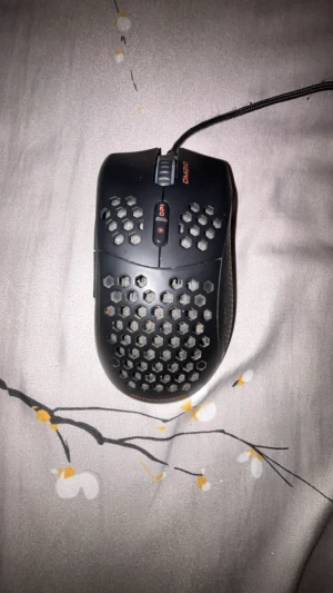 Deltaco Gaming DM210 - Lättvikts gamingmus med honeycomb-design för optimal ventilation och låg vikt. Utrustad med DPI-knapp och USB-anslutning. Synligt bruksslitage och smuts i hålen, men i övrigt gott skick. Perfekt för snabba och precisa rörelser vid spel.