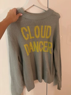 Stickad tröja med text - Blå/turkos stickad tröja från H&M i storlek XS med coolt och unikt tryck i gult på framsidan.