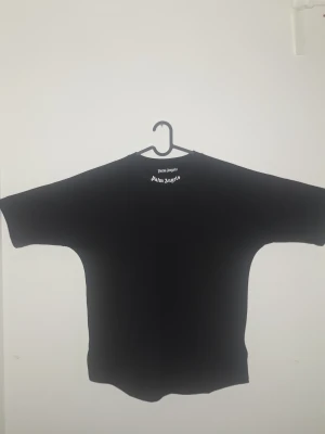 Palm Angels t-shirt  - Svart oversized t-shirt från Palm Angels med stort vitt logotryck på ryggen och mindre tryck vid halsen. Klassisk rund halsringning och korta ärmar. Tillverkad i mjuk bomull för en skön och avslappnad vibe. Pris går att diskuteras