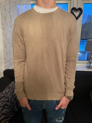 Beige stickad tröja från Selected Homme - Schysst beige stickad tröja från Selected Homme i storlek L. Tröjan har rund, stilren halsringning som passar de flesta! Tröjan är perfekt för vintern varav sin färg och även hur den håller sig varm. Skriv för mer frågor!