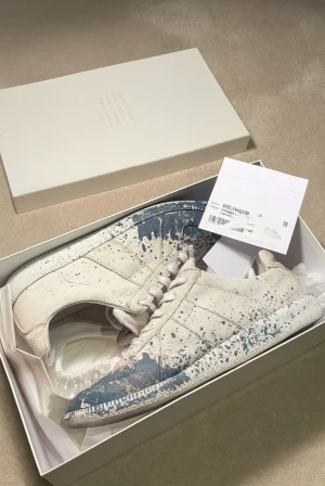 Maison Margiela paint splatter - Tja! Säljer just nu dessa feta maiden margielas! Efterfrågan på dessa är sjukt stor då de inte produceras längre av margiela. Storlek 40.  Skick : 8,5/10.  Allt og ingår✅Vårat pris = 2899kr. Hör av er vid minsta fundering🌟