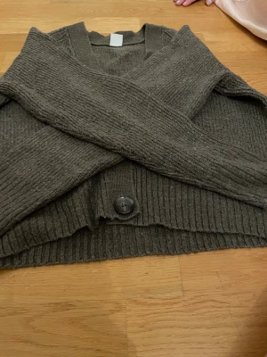 Brun stickad kofta från Lindex - Mysig brun stickad kofta från Lindex i storlek M. Koftan har ribbade muddar, stora knappar framtill och lång ärm. Perfekt för lager-på-lager och chill höst- och vinterstil.