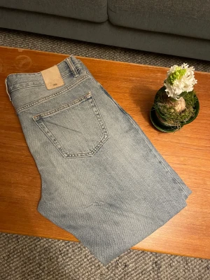Zara Nordics Straight ljusblå jeans - Säljer ett par ljusblå jeans från Zara, modell Nordics Straight. Klassisk femficksdesign med raka ben och normal passform. Jeansen är tillverkade i bomull och har en snygg, enkel look som funkar till det mesta. Perfekt för dig som gillar stilrena och raka jeans.
