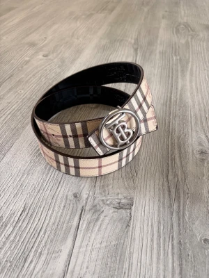  Burberry bälte - Snyggt bälte från Burberry med klassiskt rutigt mönster i beige, brunt och svart. Finns i storlek 115-125cm att bestämma sig för! 