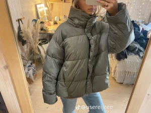  pufferjacka från H&M, S - Säljer en pufferjacka från H&M i storlek S. Jackan har hög krage, quiltad design och dragkedja med tryckknappar framtill. Modellen är loose fit och har långa ärmar. Två små fläckar på framsidan men syns bara i ett visst ljus