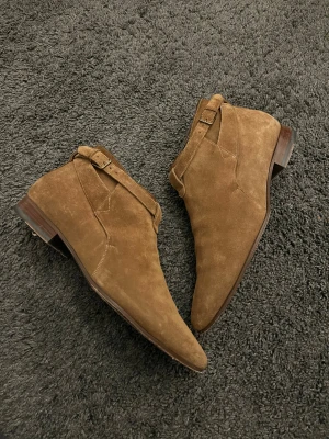 Saint Laurent Paris Jodphur Boots - Saint Laurent Paris Wyatt Jodhpur boots designade av Hedi slimane. I extremt bra skick, storlek 43. Dessa boots är väldigt svåra att hitta speciellt i lika bra skick. Kostar över 12,000kr nya. Väldigt unika och antagligen de fetaste Chelsea bootsen som går att köpa. Sulan är gjord i läder så slitningen är normal! 