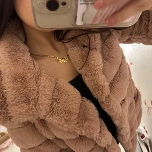 Rosa fluffig pälsjacka - Supermjuk och fluffig rosa pälsjacka med bred krage och horisontella sömmar. Jackan har tryckknappar framtill och är helfodrad. Obs en av knapparna sitter löst