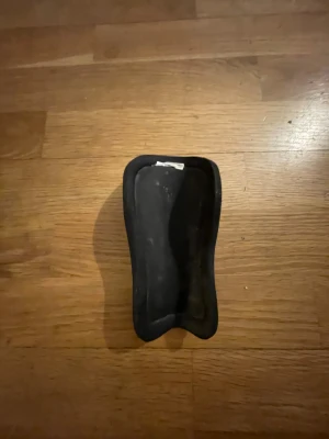 Select Advanced Benskydd - Det är ett hårt, grönt benskydd med en blank yta och blå detaljer